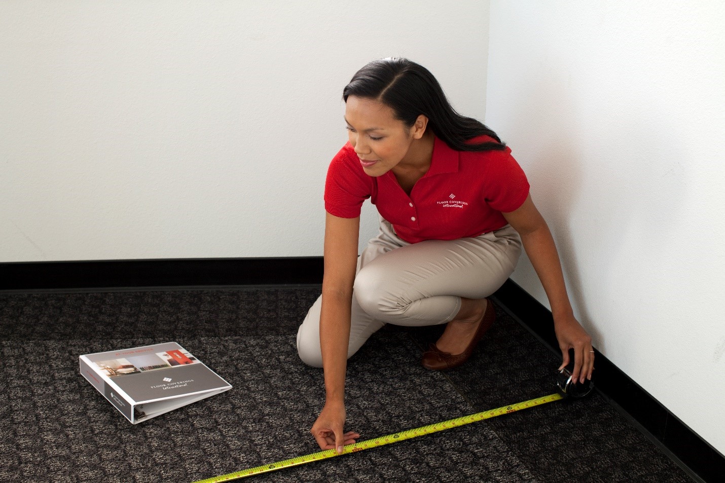 Floor Coverings International employee measuring carpet